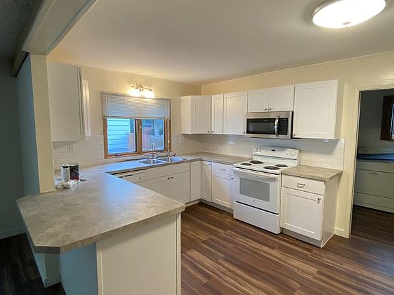 fridge is to the right of the door to the laundry room