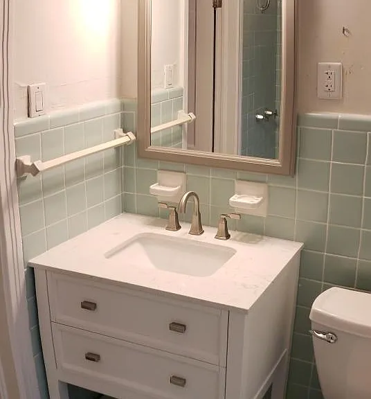 Bathroom with new vanity and toilet. Bathtub shower combination.