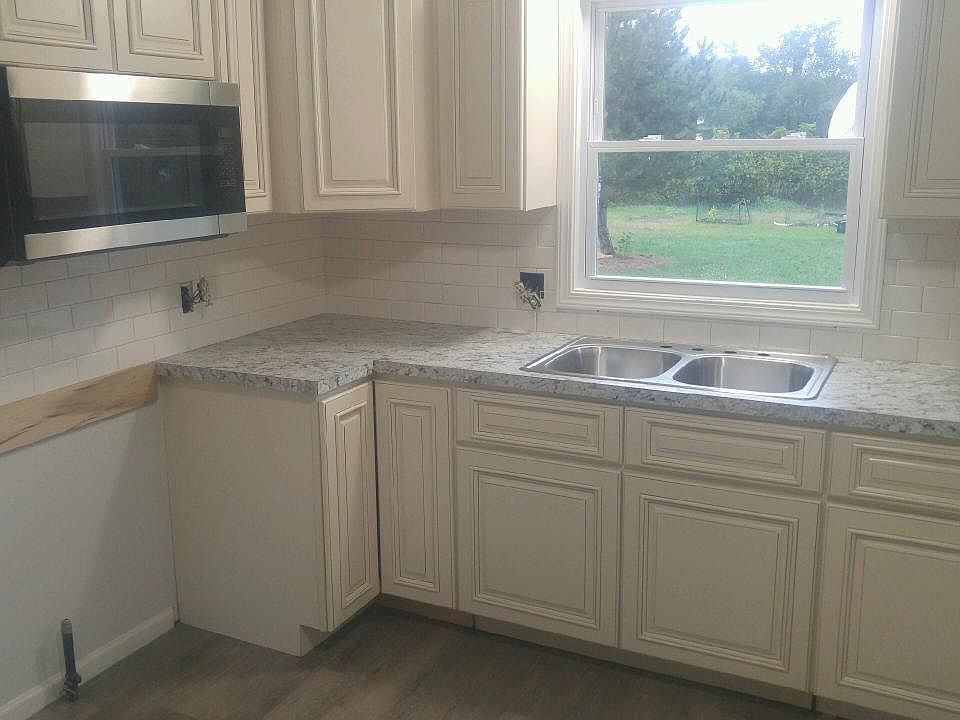 New kitchen with tile backsplash, stainless steel appliances