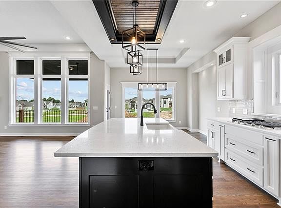 Island view facing toward back of home with floor to ceilign windows.