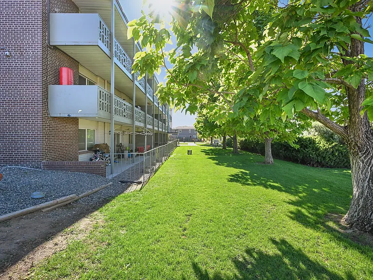 Charming apartment complex with private balconies and lush green surroundings, perfect for enjoying outdoor living.
