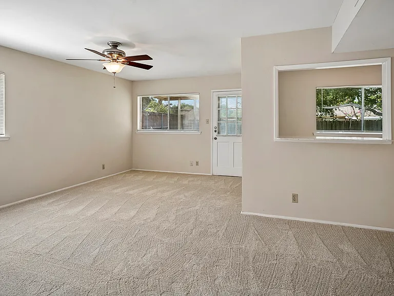 Den with bar opening to the kitchen and door to the backyard. All carpet is freshly installed.