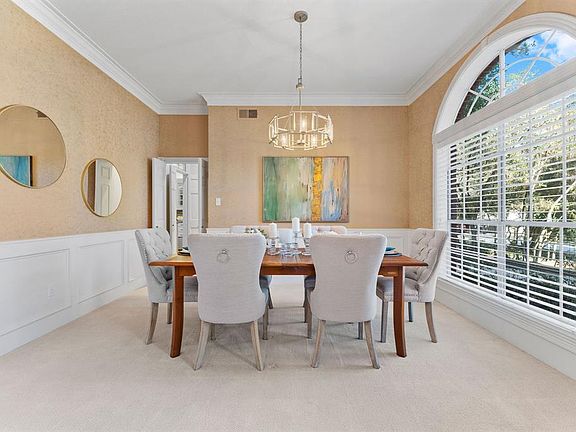 Elegant dining room with wainscoting and updated chandelier, which coordinates with the entry fixture.