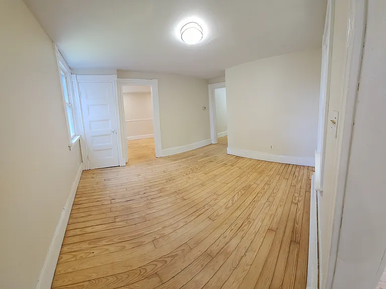 Living room looking into 1st bedroom and basement door.