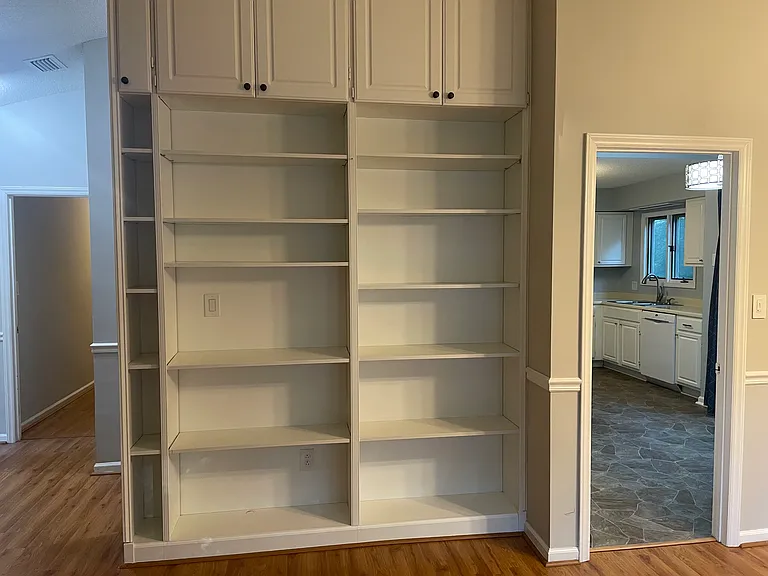 Built in bookshelves in living room, right hand door opens to kitchen