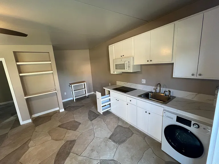 Overview of the full kitchen with appliances, spice rack, and rolling island.