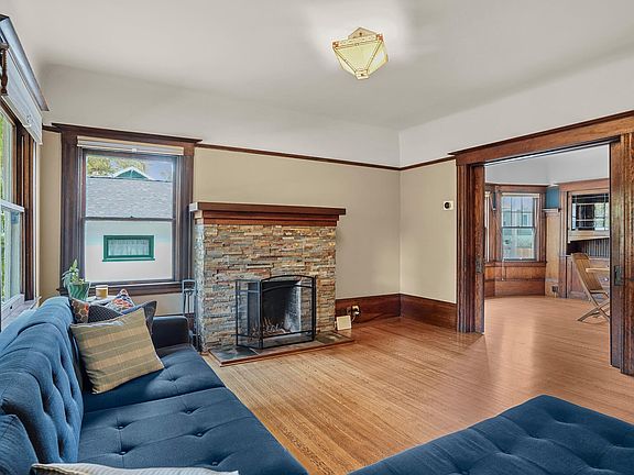 Large living room has working fireplace and three windows which let in natural sunlight. Wooden pocket doors between living room and dining room are functional and refinished.