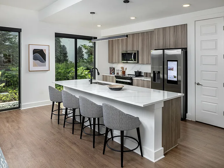 Gourmet kitchens with quartz countertops and backsplashes, modern light fixtures and stainless-steel smart refrigerators