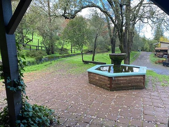 Rustic fountain stocked with fish adds to the tranquility of this lovely landscape.