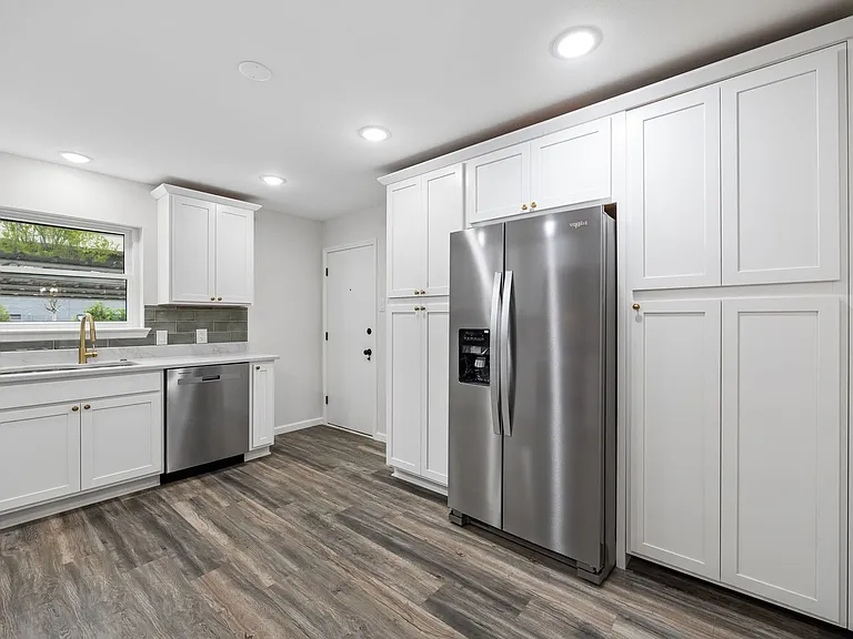 Kitchen featuring white shaker cabinetry, stainless steel appliances, wood-finish flooring, recessed lighting, and a white countertop with a gray subway tile backsplash