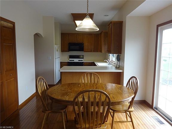 Eat-in kitchen with hardwood floors and slider to patio