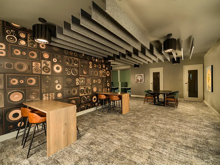 A shared lounge with acoustic detailing, communal tables, and flexible seating designed for collaboration, creativity, and focused moments throughout the day.