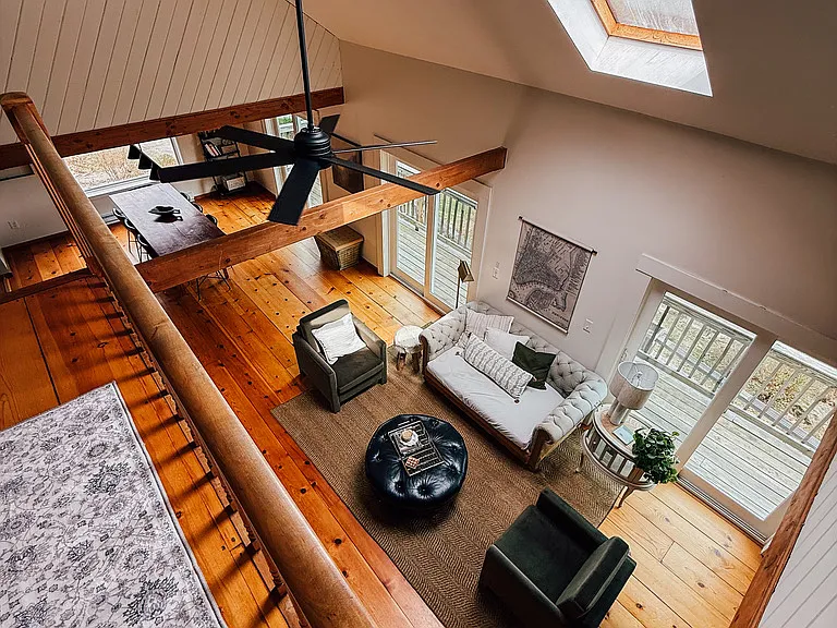 View from above of fireplace sitting area, ceiling fan and skylight, and dinning table