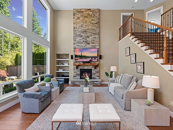 Family room with dramatic 2-story fireplace with floor-to-ceiling stone surround.