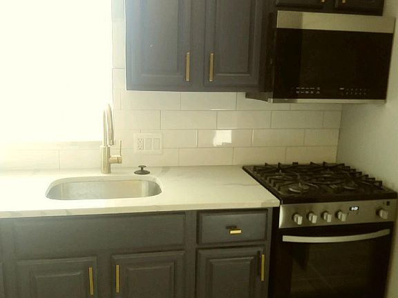 Brand new range, microwave, and refrigerator. Navy Blue Cabinets.