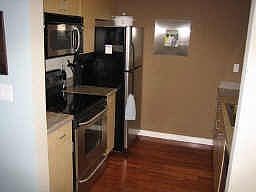 kitchen with walnut hardwood floors and stainless steel appliances