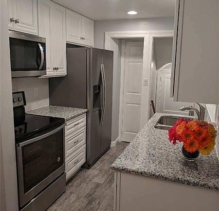 WELL-DONE KITCHEN WITH SS. APPLIANCES, GRANITE TOPS, PORCELAIN  FLOORS.