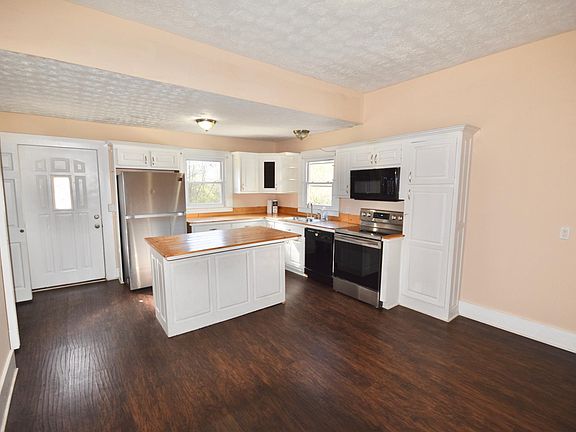Open kitchen/breakfast area with new appliances, newer flooring & laundry area
