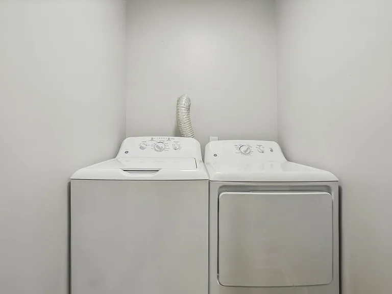 Dedicated laundry nook with a full-size washer and dryer, offering convenient in-home laundry and easy access.