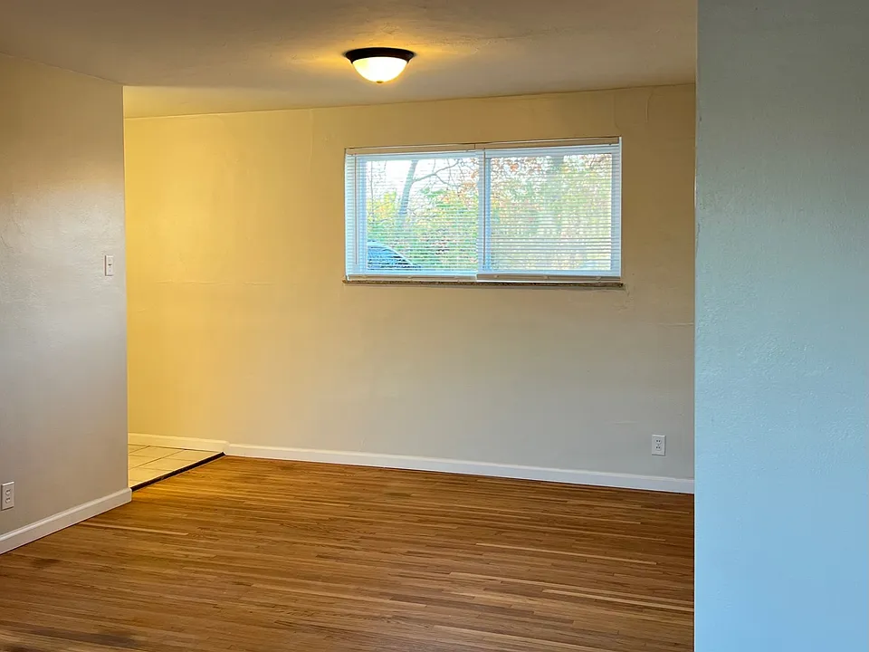 Living room looking into the dining room space. Kitchen is to the left where you see the tile floor.