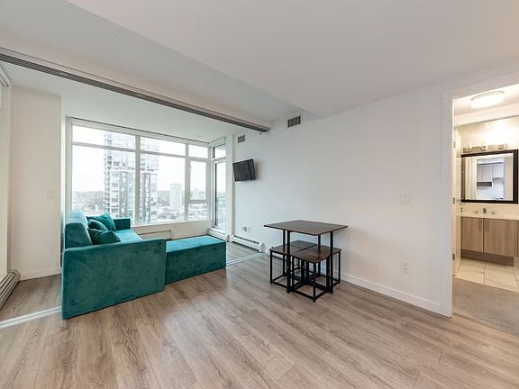 The dining area and kitchen offer a lovely view of the surrounding space, with large windows that let in natural light.