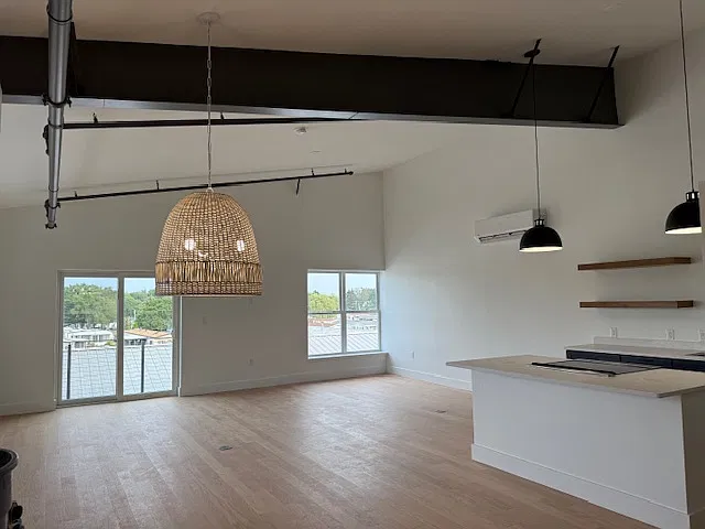 Living Area with loft like features of freshly painted exposed beams.