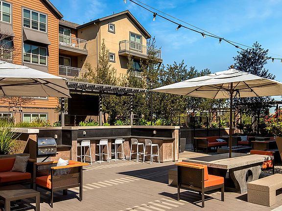 BBQ and picnic area with picnic tables, bar seating, and umbrellas.