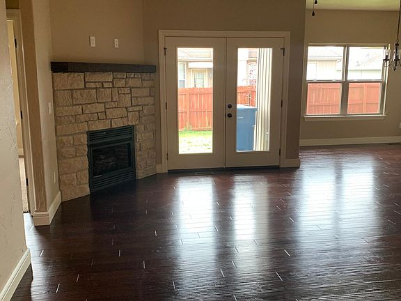 Entry way, showing engineered hardwoods, fireplace and opens to the right to the kitchen/master bedroom/laundry room; bedrooms to the left