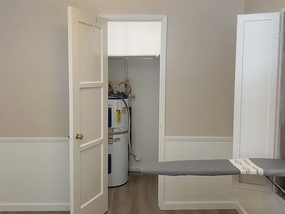 KITCHEN NOOK AREA WITH NEW CEILING FAN, FOLD DOWN IRONING BOARD, NEW PLANK FLOORING & CLOSET AREA WITH WATER HEATER.