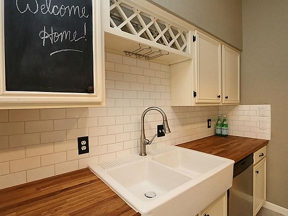 Farmhouse sink with butcher block counters and a wine rack!