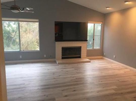 Spacious front room with fireplace, updated flooring, ceiling fan, plenty of natural lighting, designer paint.