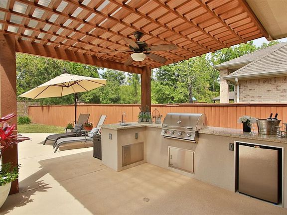 Underneath the rainproof Pergola you will find a great outdoor kitchen featuring a stainless steel built in gas grill, a mini fridge, a sink with stor