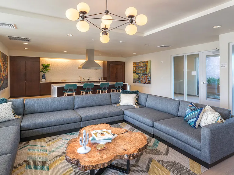 Spacious lounge with sectional seating and open kitchen.