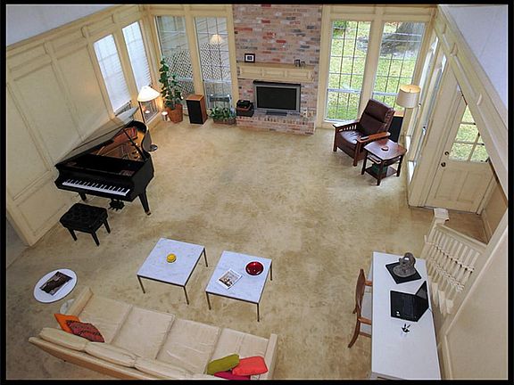 Overhead view showing the size of this great room with wood paneled walls and fireplace.