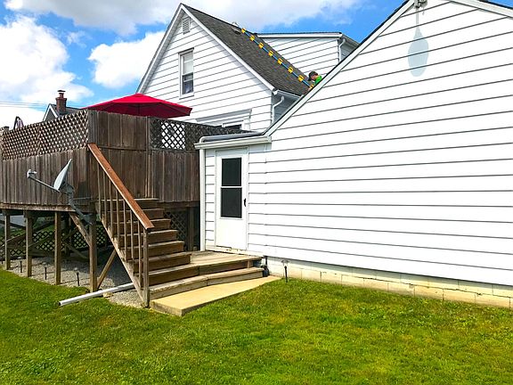 Pictured: backyard, back door from enclosed porch/breezeway and the raised deck.