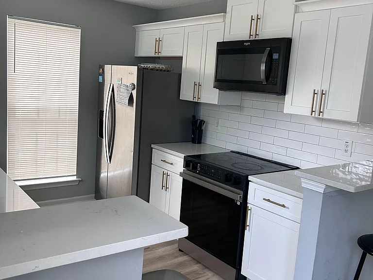 Updated kitchen with shaker cabinets, ample counter space, and stainless-steel appliances for everyday cooking.