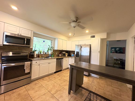 Large eat in kitchen with granite counters and stainless steel appliances