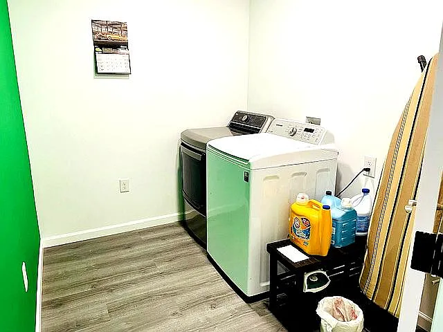Washer and dryer in laundry room with ironing board, iron provided.