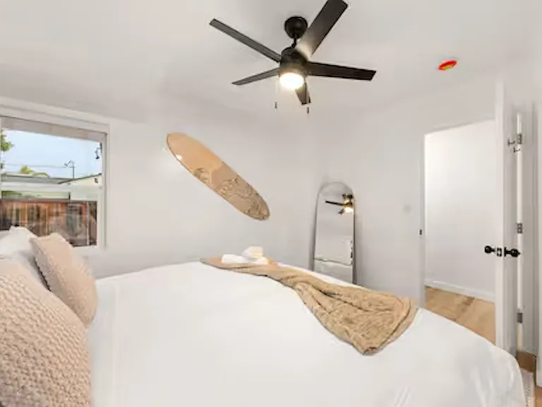 Bedroom 2 is bright and airy with windows and blackout blinds, featuring a king bed, ceiling fan, and a lampshade with extra outlet and USB ports for easy device charging. Ample closet space completes this comfortable and convenient retreat.