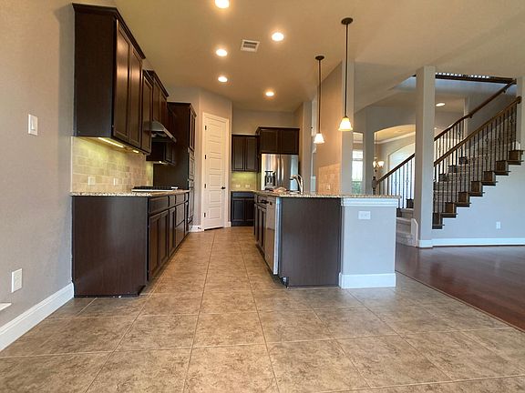 kitchen dining looking to kitchen area. lots of light with spot lights at island, recessed overhead and under counter lighting too