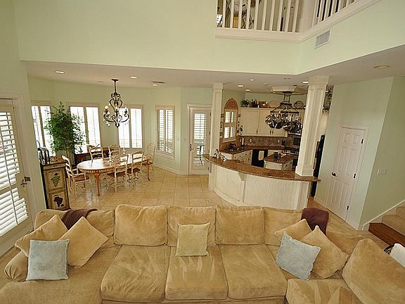 Open living/dining/kitchen spaces with travertine tile floors,  The home is offered furnished with exclusions.