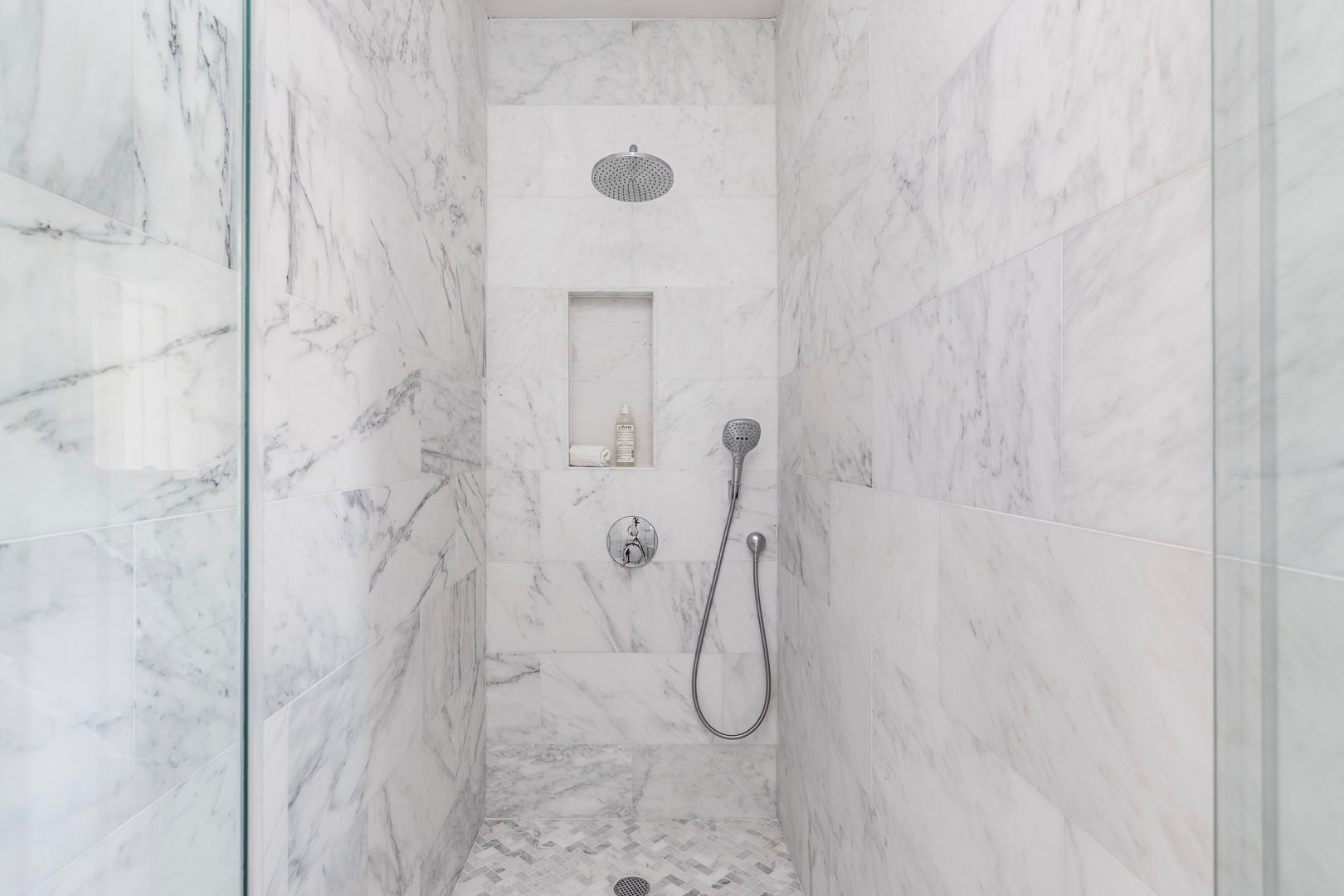  Guest bathroom features marble interiors. Walk-in rain shower and vanity sink.

