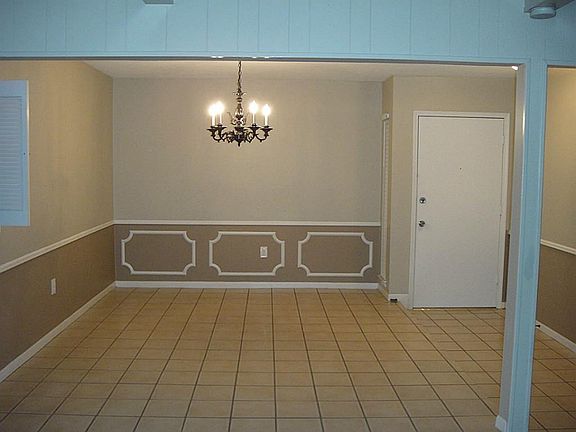 Formal dining room with tile flooring and decorative molding.