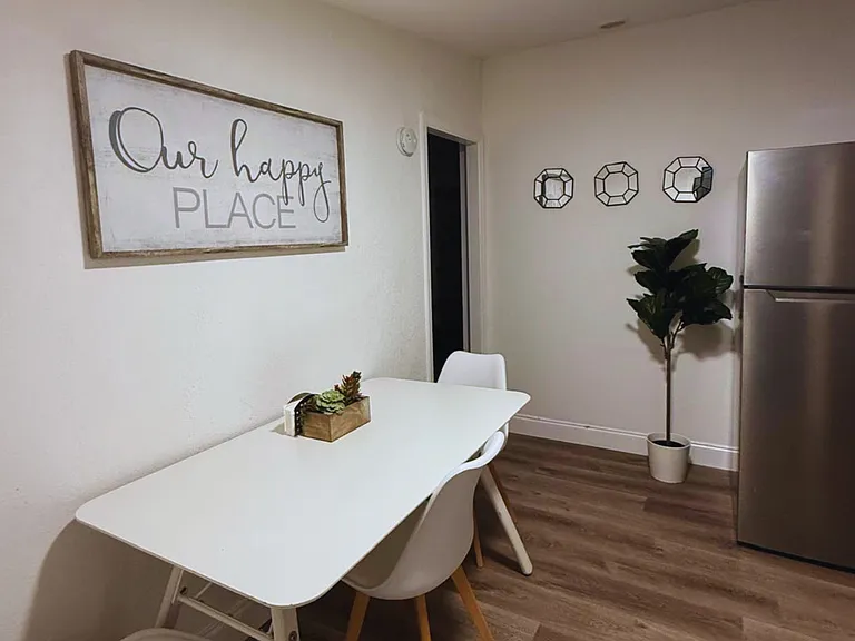 Inviting dining area for 3 with decorative greenery and stylish wall art.