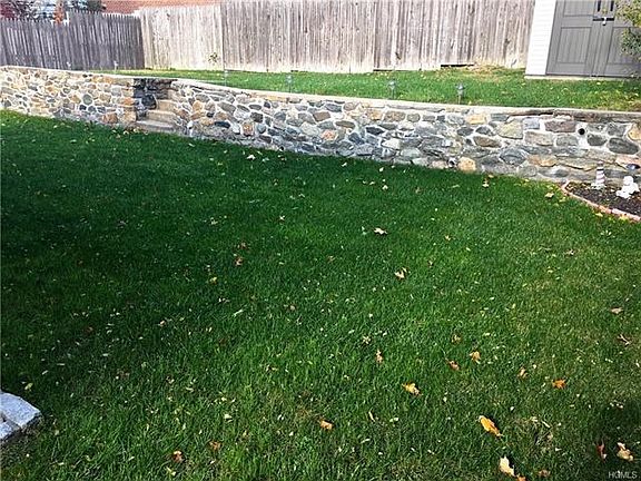 Unique rock wall with double-layered backyard w/shed!