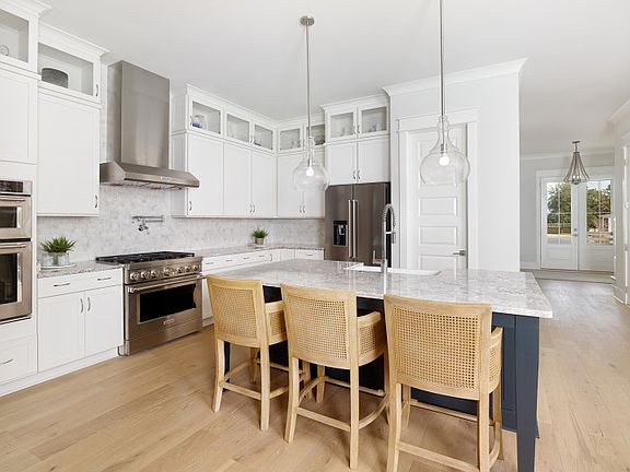 Beautiful Gourmet Kitchen with White Cabinets, Quartz Countertops, and a large island with a Farmhou