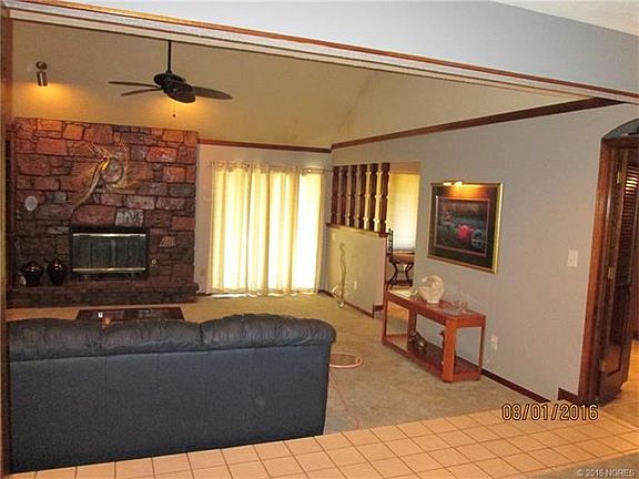 Formal Living with beautiful stone woodburning fireplace. Sliding glass doors to back covered patio.