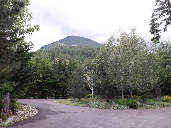 View of private setting and circular drive, to the left RV or boat parking and storage shed for gard