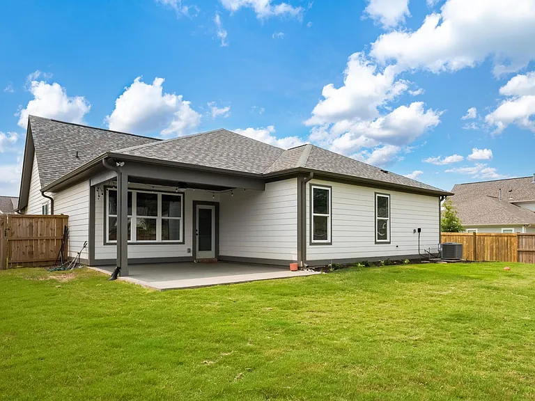 fenced back yard with covered patio
