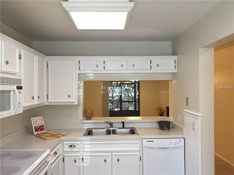 Spacious and bright kitchen overlooking living/dining room, backyard view and wood burning fireplace!